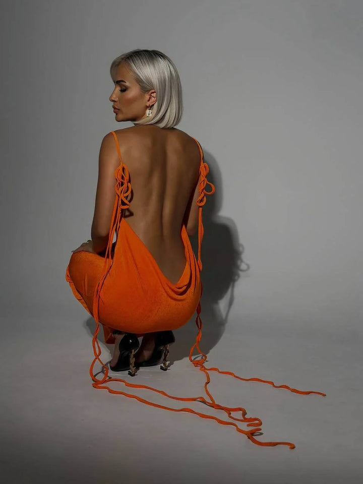 "Orange Aaira backless dress with adjustable ties, sleek modern design, perfect for casual outings or beach days."