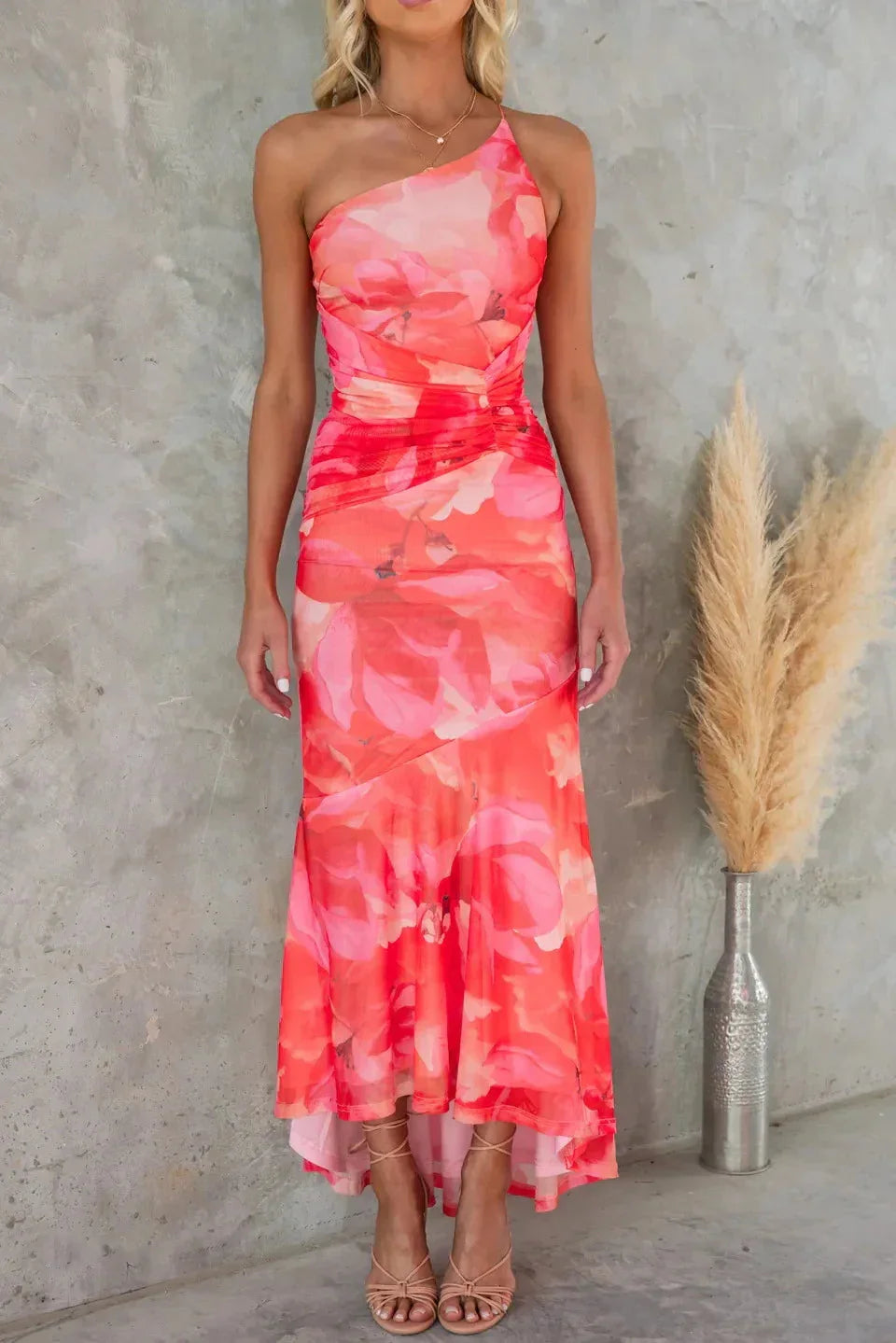 Strapless floral maxi dress with asymmetrical hem, made from lightweight fabric.
