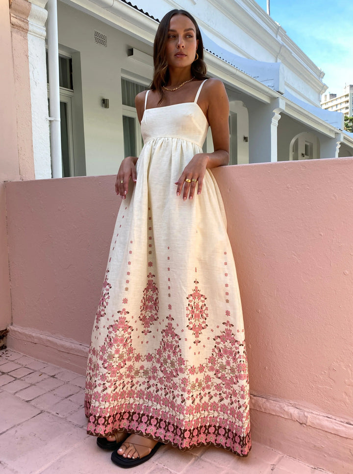 Floral white summer dress featuring intricate hem detail, perfect for warm weather outings.
