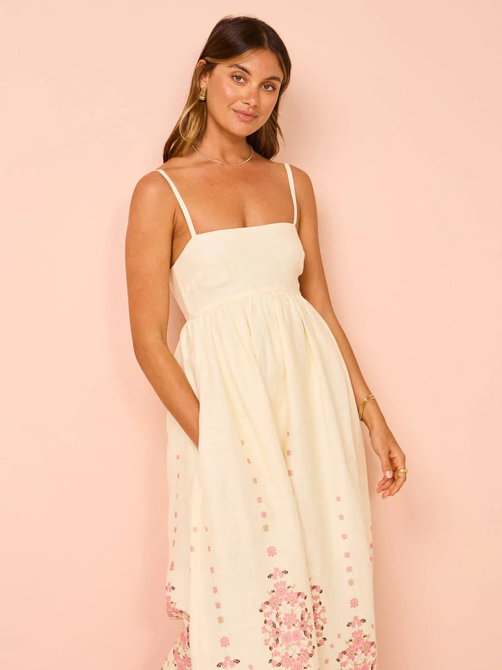 "White summer dress with floral print and intricate hem detailing, ideal for sunny days out."