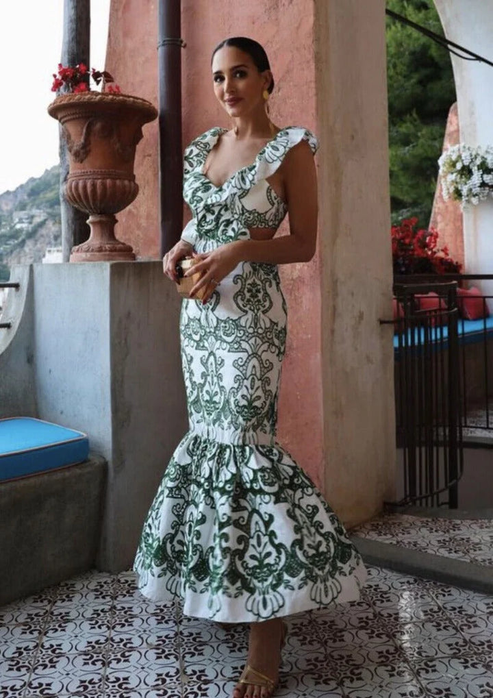 White and green ruffled maxi dress with a flowing design and botanical print made from lightweight breathable fabric.