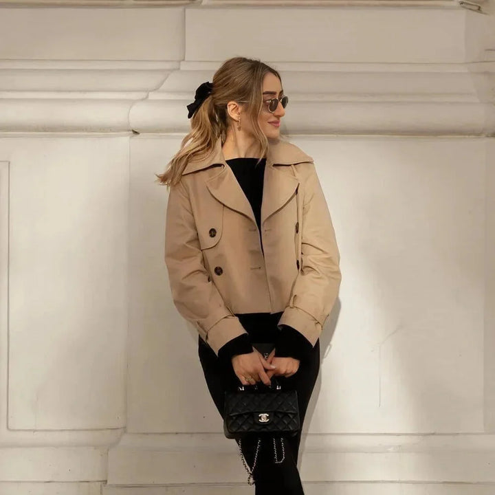 Black double-breasted cropped jacket with collar and front pockets. Made of wool blend, perfect for year-round styling.