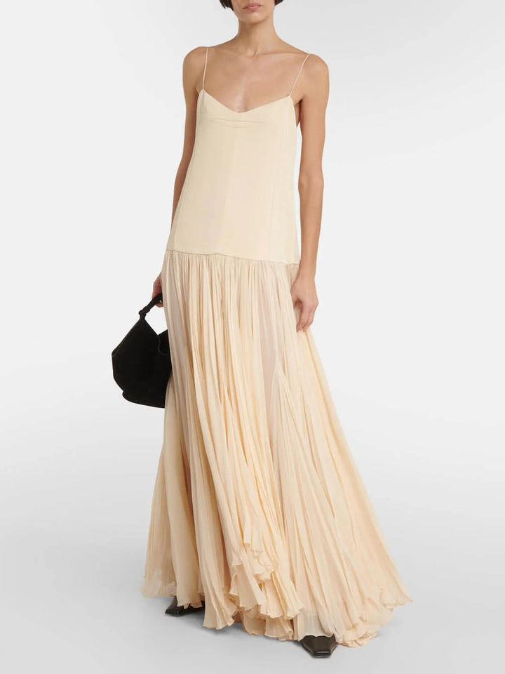 "Sleeveless ivory maxi dress featuring pleated design, crafted from lightweight fabric. Perfect for a chic and elegant look."
