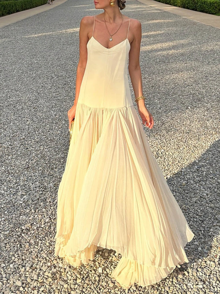 Sleeveless ivory pleated maxi dress with a flowing silhouette and intricate pleating detail.