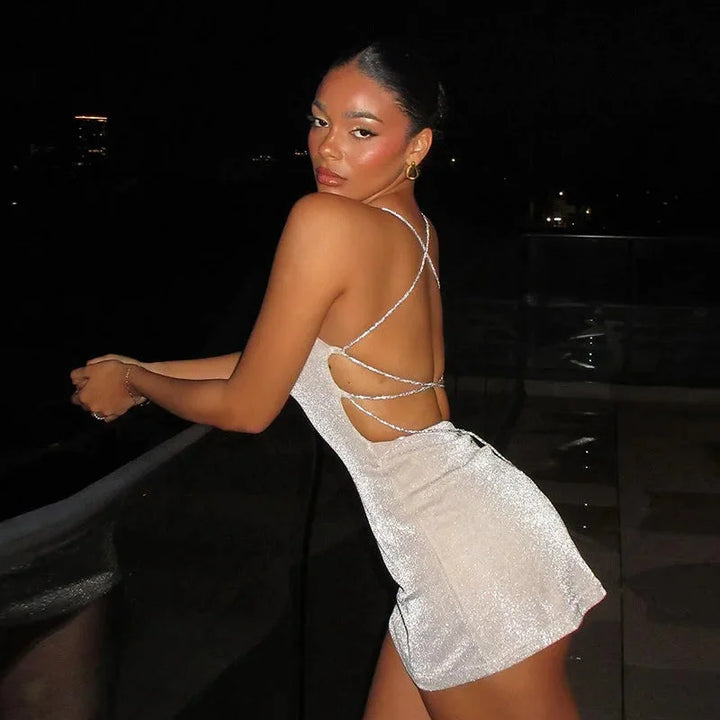 Black mini dress with sparkly sequins, featuring an alluring open back design by Akari.