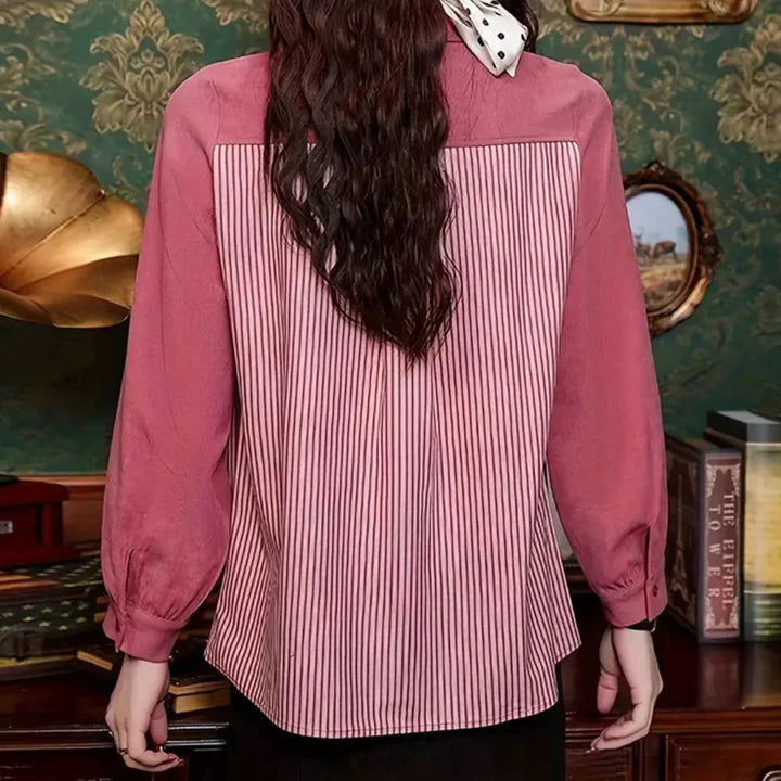 Pink striped blouse with contrast details, featuring a soft cotton blend fabric and subtle yet stylish design elements.