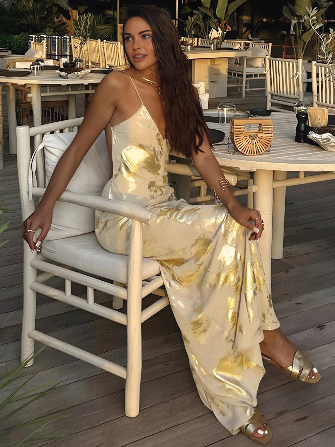 Gold foil satin maxi dress with thin straps, elegant and shiny fabric for a formal event or evening occasion.