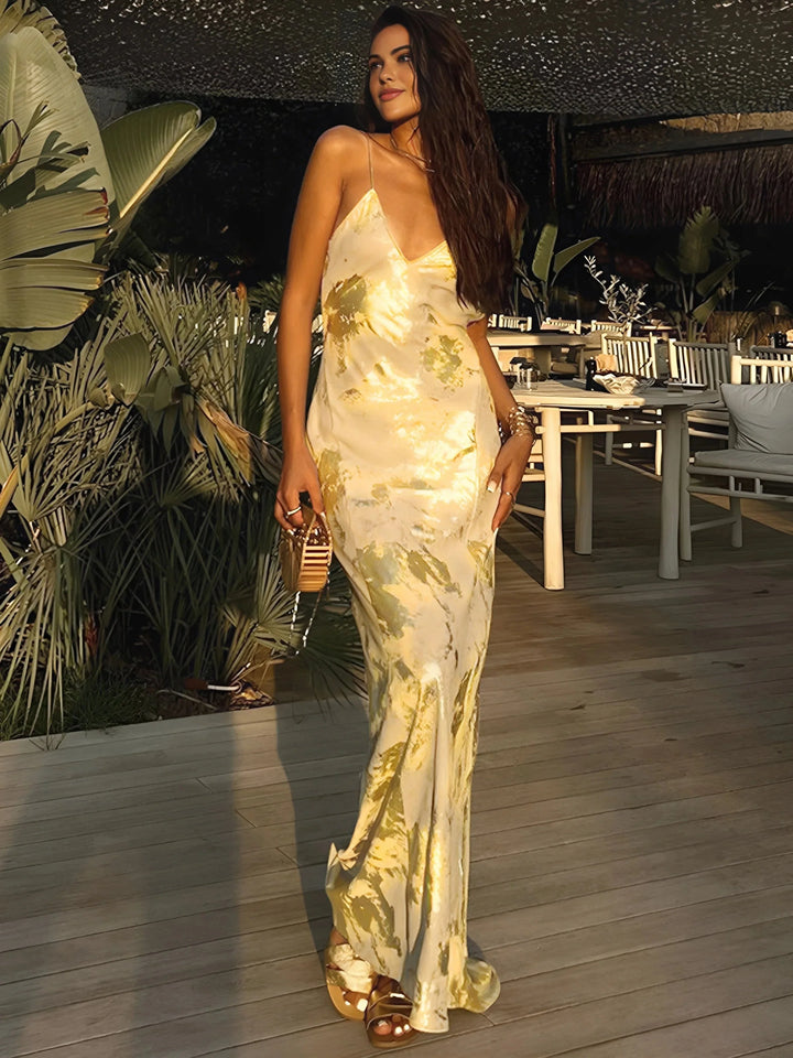 Gold foil satin maxi dress with thin straps, sleek design, and shiny finish, ideal for special occasions and elegant…