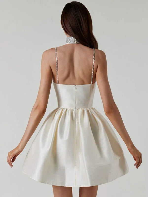 Satin mini dress with rhinestone straps, perfect for a glamorous evening look.