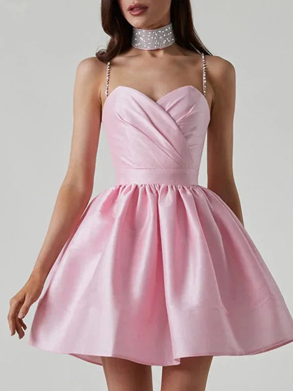 Pink satin mini dress with rhinestone strap detailing for a glamorous look.