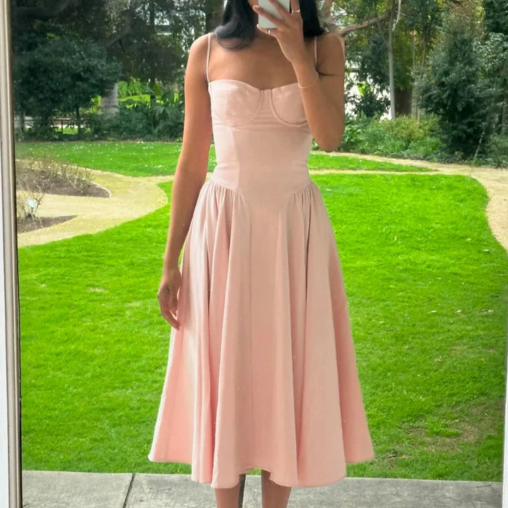 Pink bustier midi dress with flared skirt for women, made from soft fabric, featuring a flattering design perfect for any…