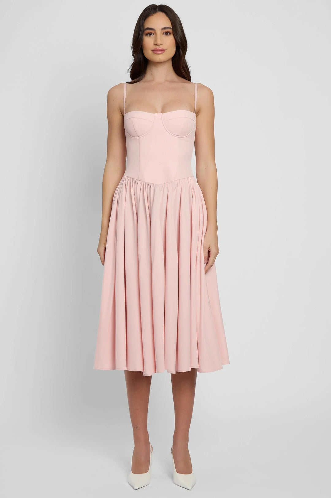 Women's pink bustier midi dress with flared skirt, featuring a structured bodice and flowy silhouette, perfect for a playful…