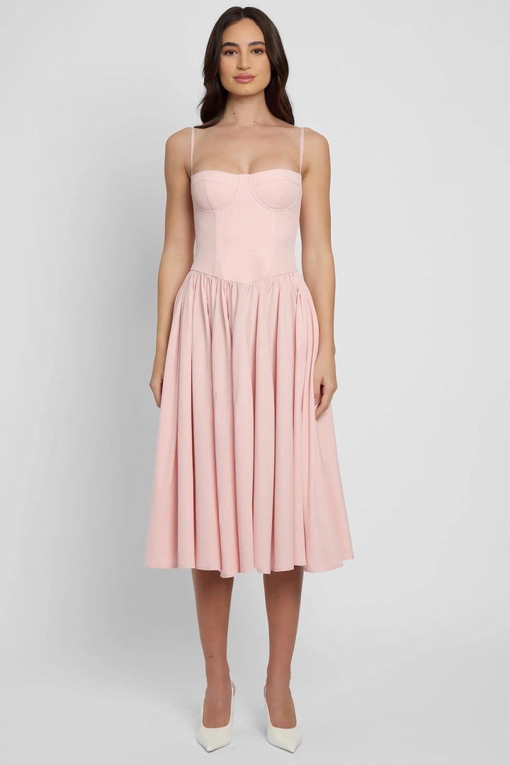 Women's pink bustier midi dress with flared skirt, featuring a structured bodice and flowy silhouette, perfect for a playful…