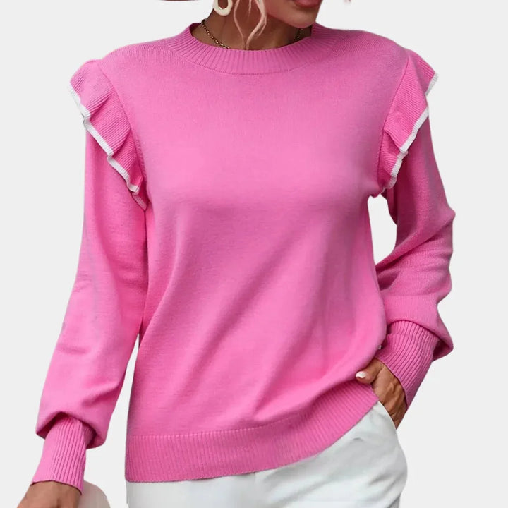 Pink crewneck sweater with charming ruffle trim detailing. Soft and cozy material for a feminine touch.