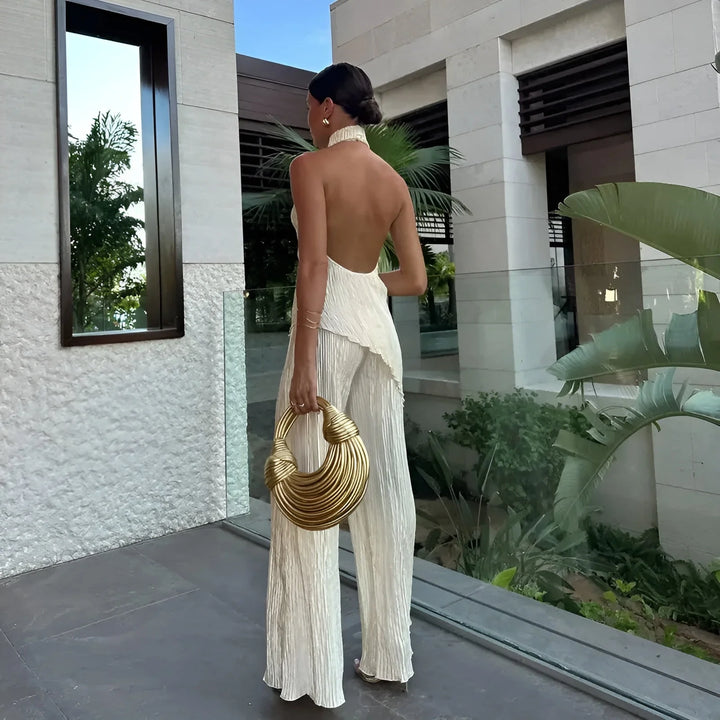 White pleated halter top jumpsuit in airy, lightweight fabric with a flattering silhouette.