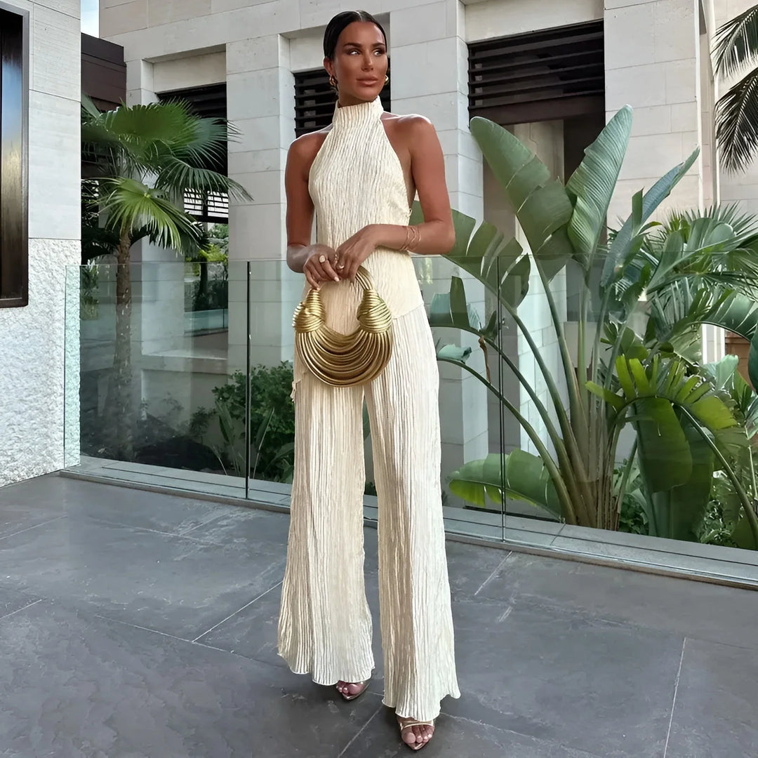 White pleated halter top jumpsuit in a lightweight, airy fabric with a flattering silhouette.