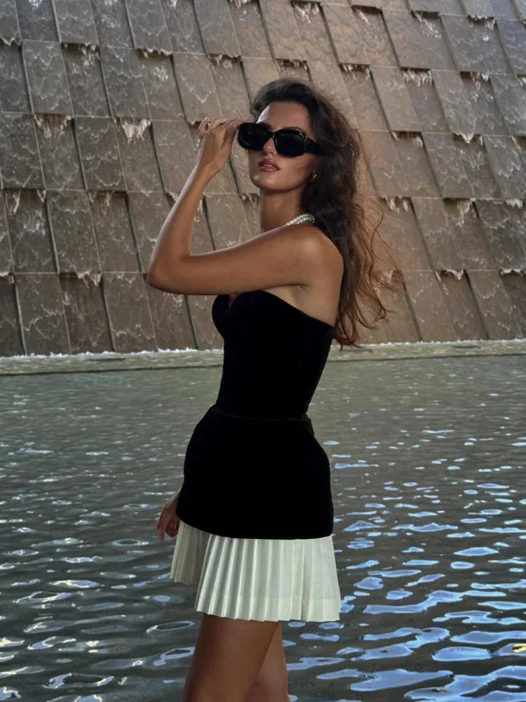 Strapless black top with white pleated skirt, chic and elegant outfit for a formal event.