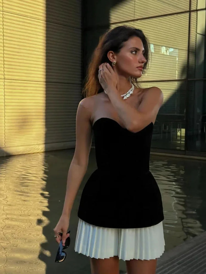 Strapless black top with white pleated skirt, a stylish summer outfit made for effortless elegance.