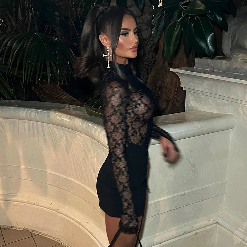 Black form-fitting mini dress made of soft cotton blend with intricate lace detailing on sleeves and hem.