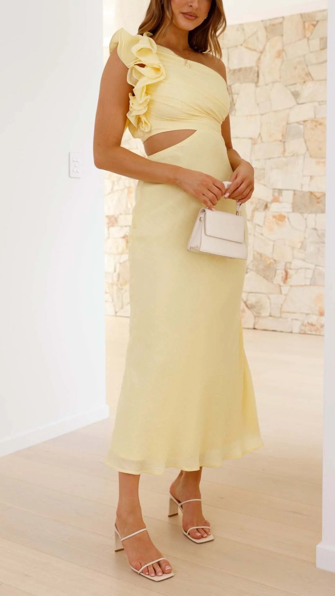 Yellow one-shoulder maxi dress with cutouts, made of flowy fabric, featuring a stylish asymmetrical design.
