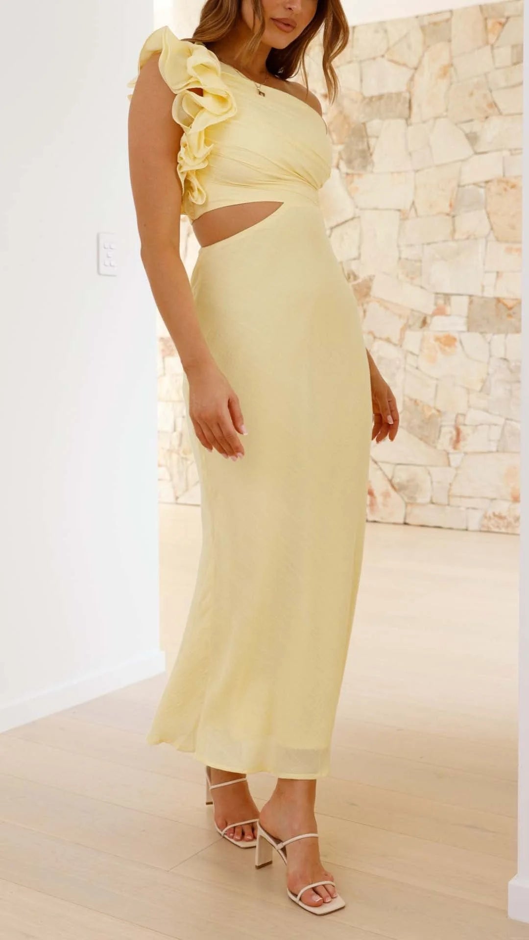 Yellow one-shoulder maxi dress with cutouts, made of flowy fabric. Features a chic design with a stylish asymmetrical…