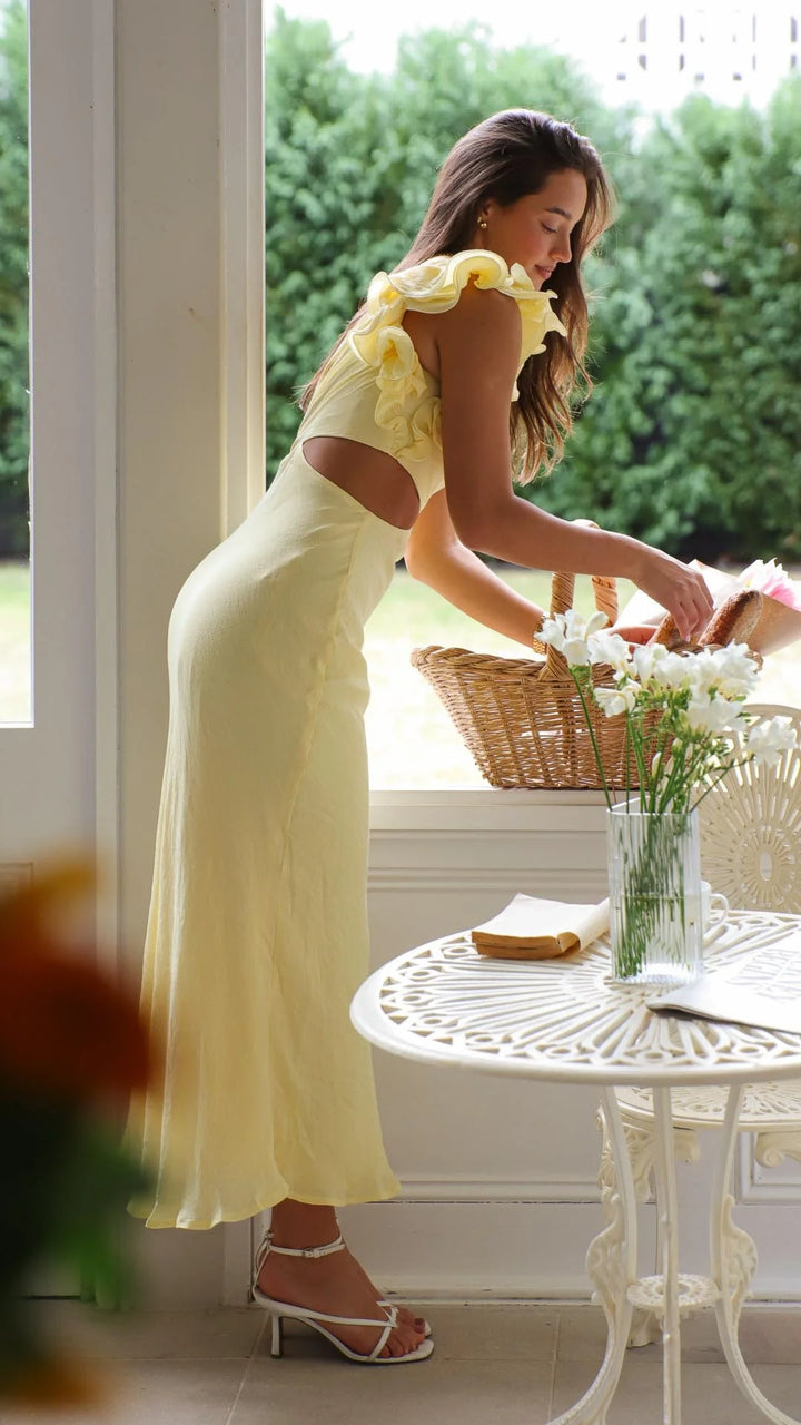 Yellow one-shoulder maxi dress with cutouts, made from soft and flowing fabric, perfect for an elegant and stylish look.