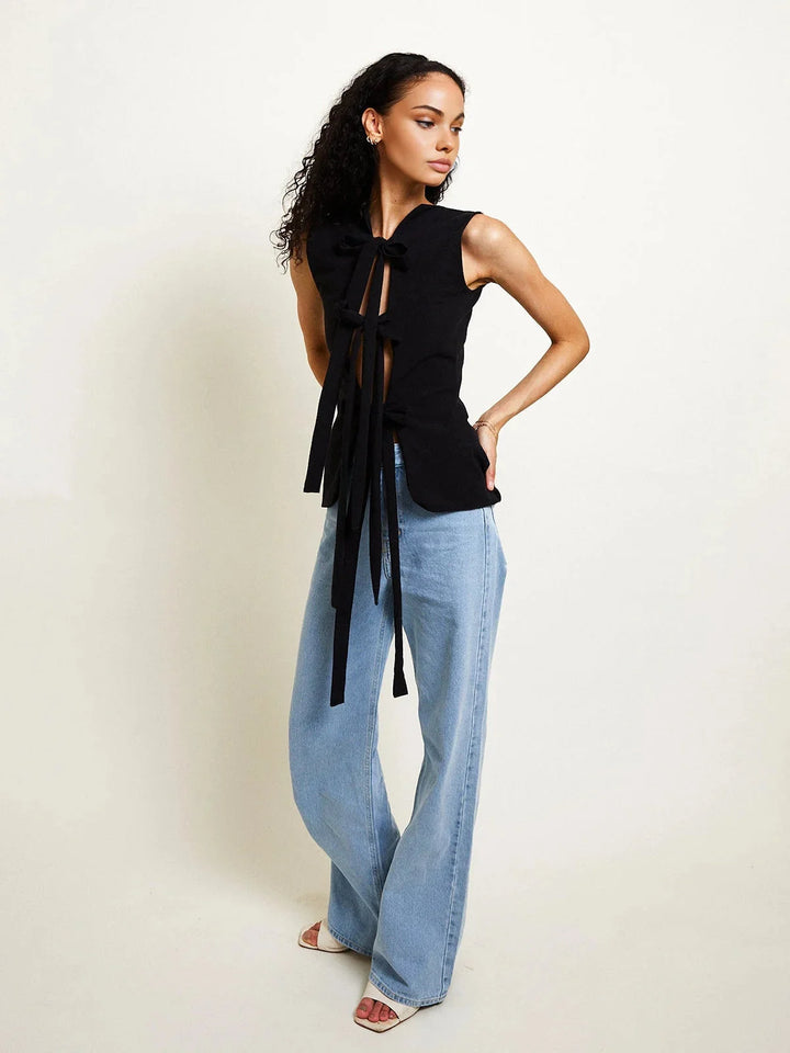 Sleeveless top in soft blue with tie-back design. Adjustable fit for versatile styling, perfect for casual or dressy looks.