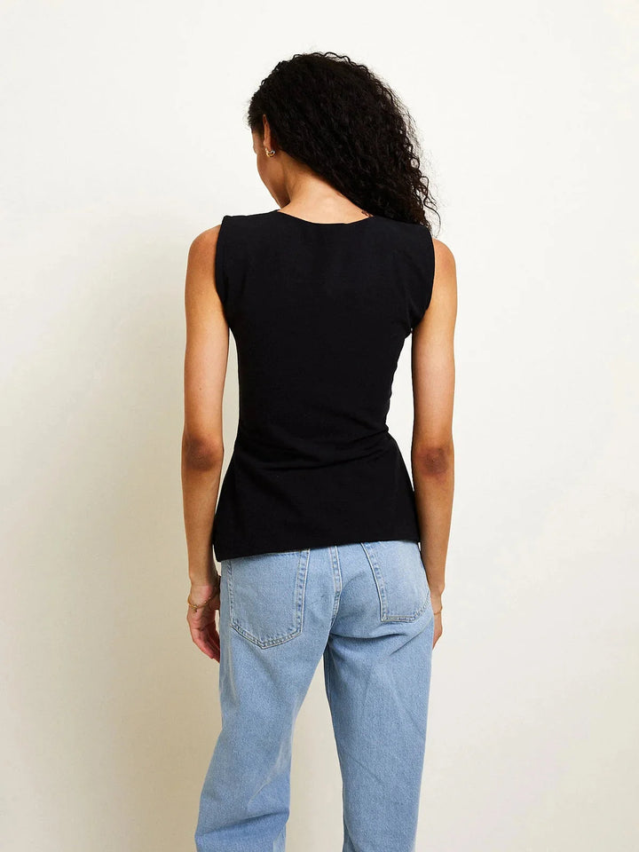 Sleeveless top with tie-back detailing, made of breathable cotton blend fabric. Features adjustable straps for a…