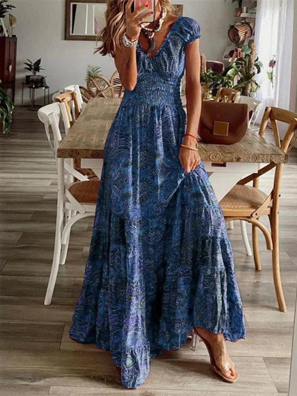 Blue bohemian V-neck maxi dress with tiers, made of breathable cotton blend. Flowy silhouette with intricate pattern details.
