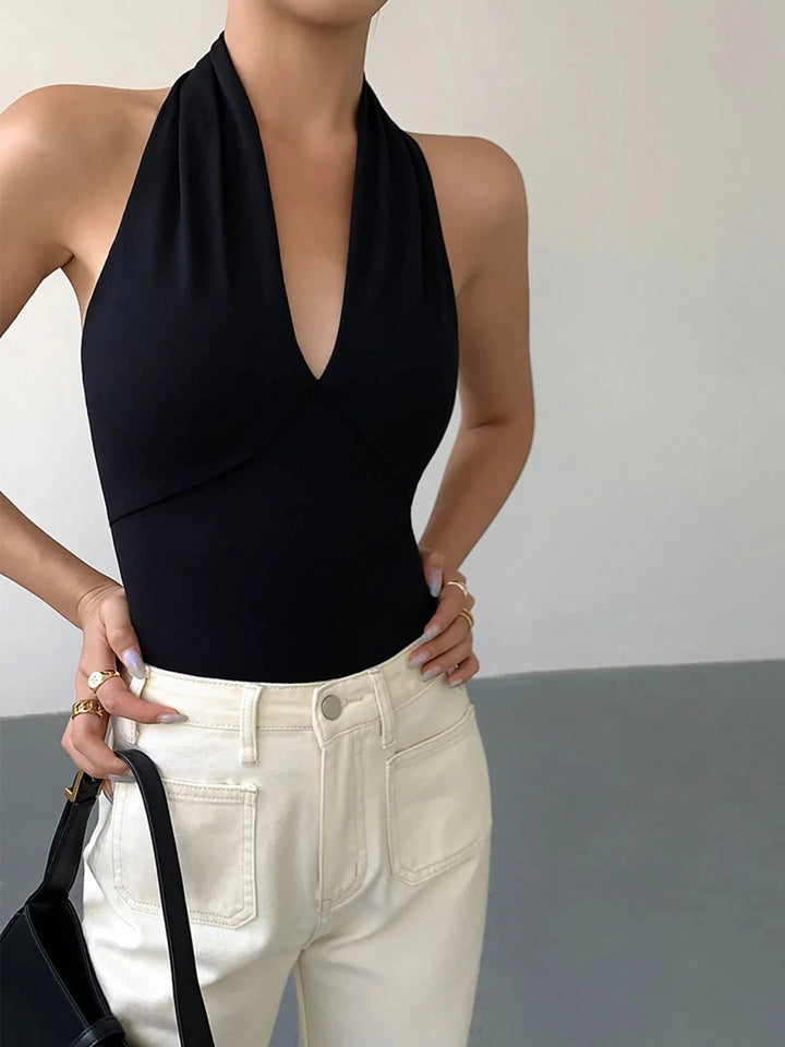 Black halter top with unique crossover design, made from sleek and comfortable material by Aryana.