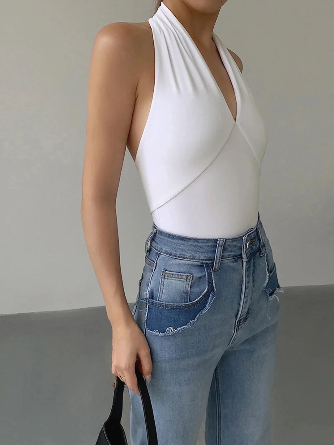 White halter crossover top in a sleek design by Aryana. Made of soft, stretchy fabric, perfect for casual or dressy outfits.