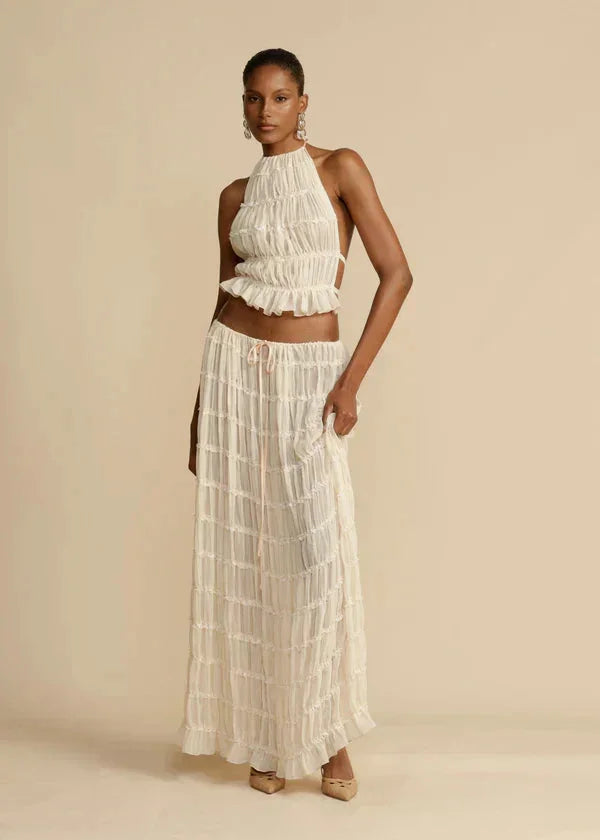 "Two-piece ruffled ivory skirt set for women, featuring a stylish asymmetrical design with soft and flowing fabric."