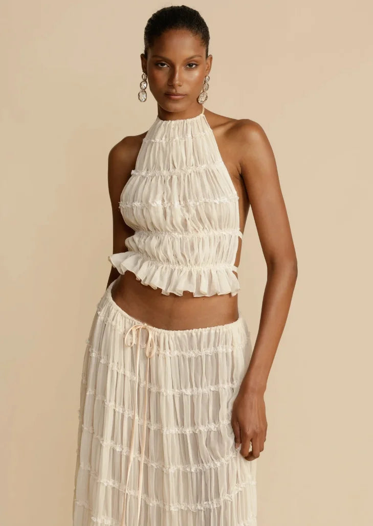 Ivory ruffled two-piece skirt set for women by Aryiah, featuring a textured fabric with delicate ruffles and a matching top…