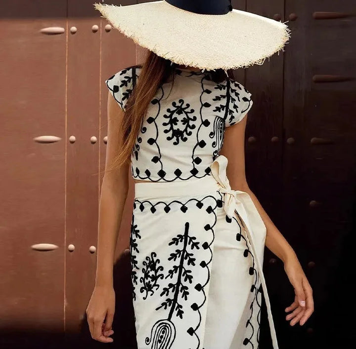 "Two-piece set featuring sleeveless top with intricate embroidery paired with a flowing skirt in a coordinating design."