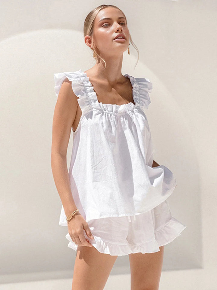 Sleeveless top and shorts set in white with ruffled accents. Perfect summer outfit with a breezy design.