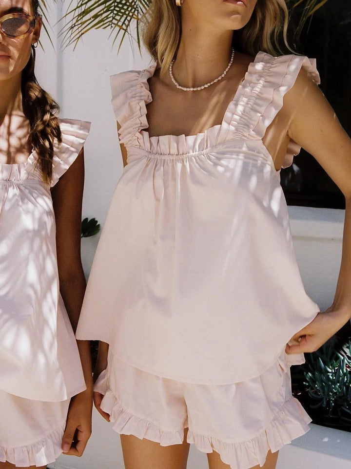 Pink ruffled sleeveless top and matching shorts set in a soft, lightweight fabric with a feminine and stylish design.