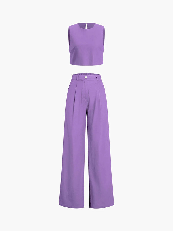 Purple crop top and wide-leg pants set. Asymmetrical design. Made from soft, flowy fabric for a stylish and modern look.