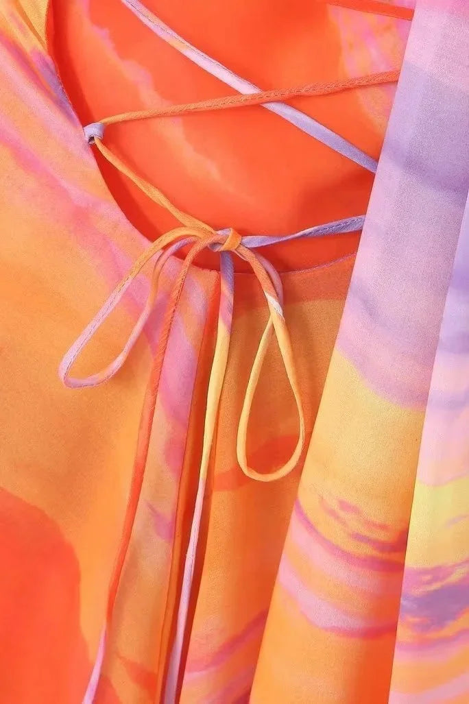 Halter mini dress in sunset tones with a flowing silhouette and a flattering fit. Perfect for summer outings and beach…