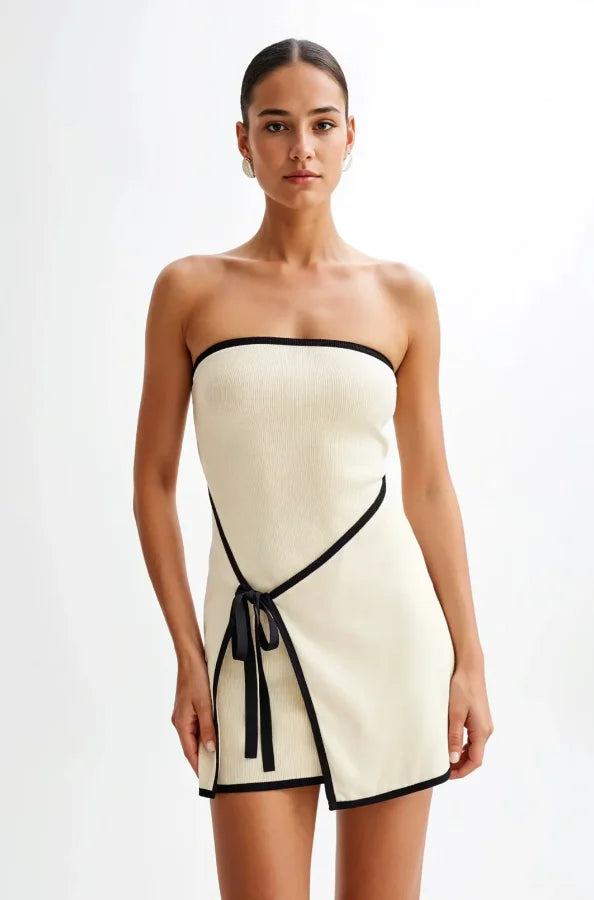 Strapless mini dress in neutral hue, featuring a flowy silhouette with a tie waist detail, perfect for a casual yet chic…