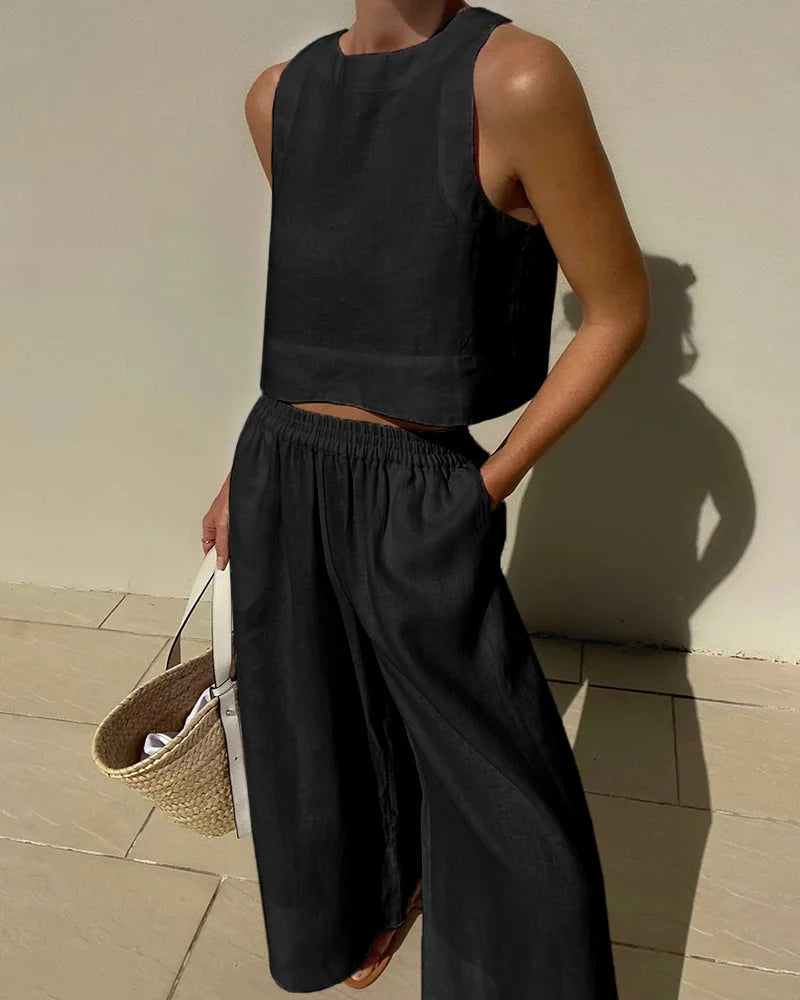 Sleeveless black top paired with flowing pants set, crafted from soft, lightweight fabric. Comfortable and stylish casual…