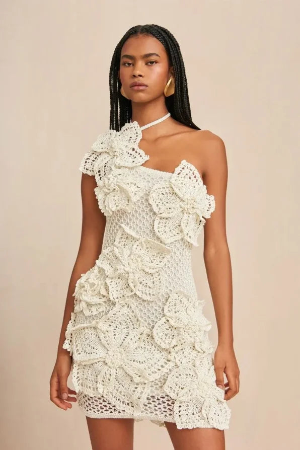 Off-shoulder white crochet dress with intricate floral pattern detailing, perfect for a bohemian-inspired look.