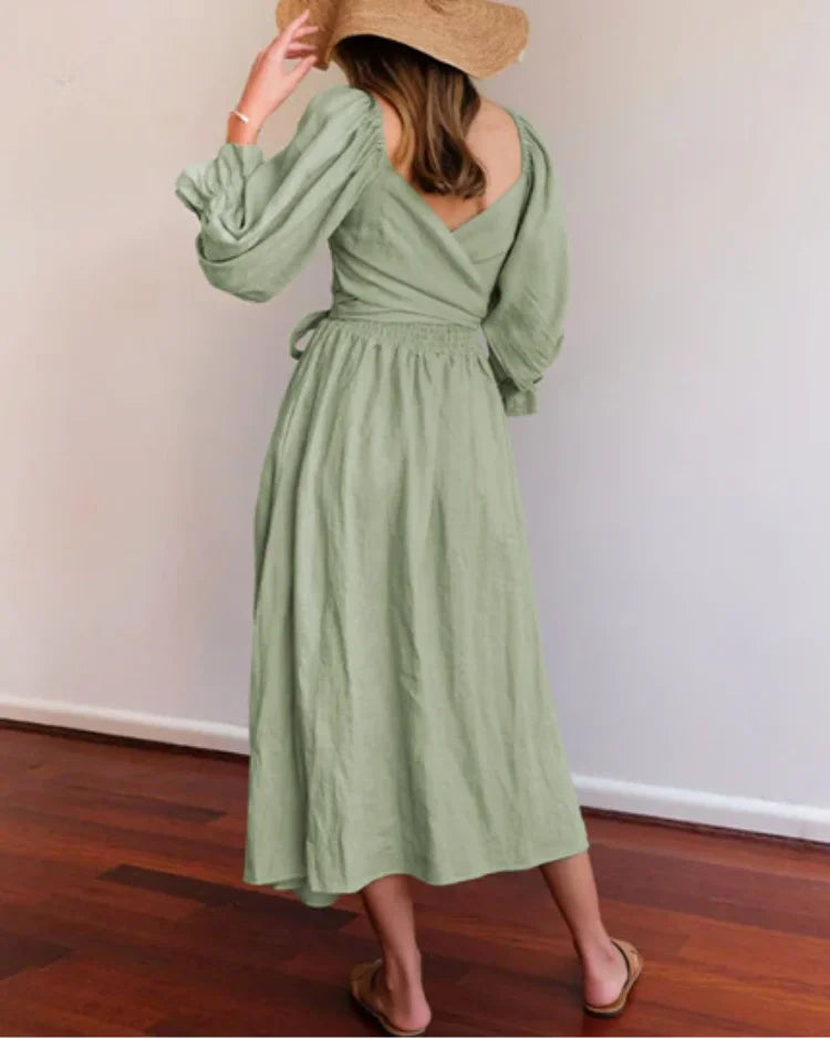 Navy blue wrap dress with a deep V-neckline, made from soft cotton blend fabric. Elegant and versatile for any occasion.