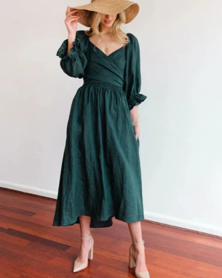 Dark green wrap dress with deep V-neckline, made from soft and flowy fabric. Flattering silhouette for a stylish look.