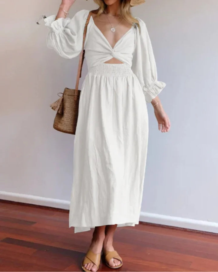 White wrap dress with deep V-neckline by Avelina, made from lightweight cotton blend. Flattering silhouette with elegant…