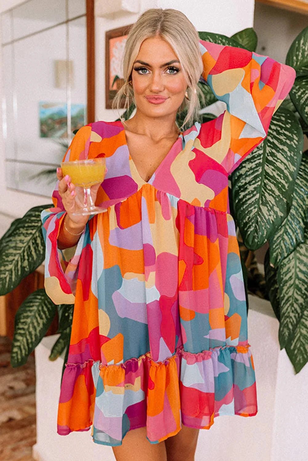 Colorful geometric print V-neck babydoll dress made of lightweight cotton blend fabric, perfect for casual summer outings.
