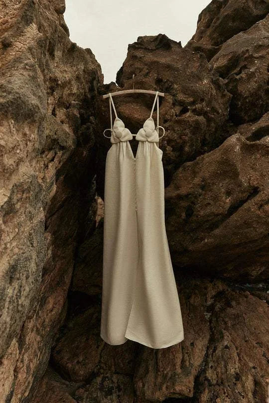 Beige maxi dress with floral detailing and slit, perfect for a feminine and elegant look.