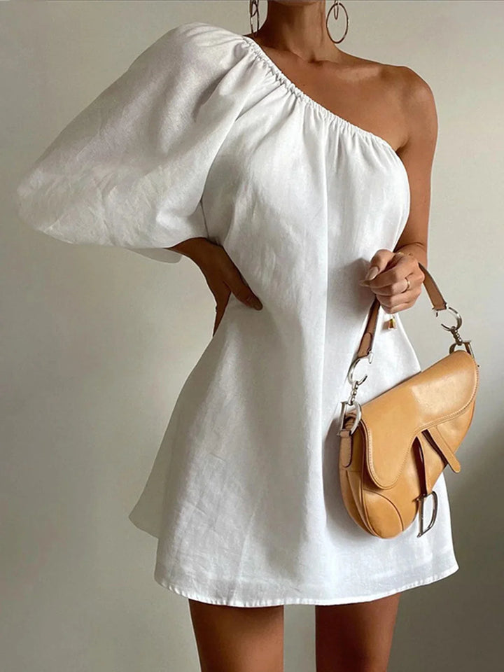 White off-shoulder mini dress with puff sleeves made from soft cotton. Feminine and trendy style perfect for casual days or…