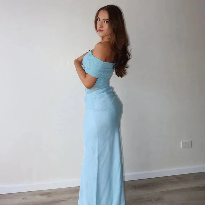 Off-shoulder ruched maxi dress showcasing a waist cut-out detail. Flowy, elegant design in a lightweight fabric, perfect for…