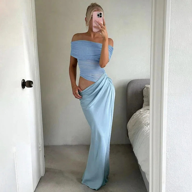 Blue off-shoulder maxi dress with ruched detailing, waist cut-out, and flowing silhouette.
