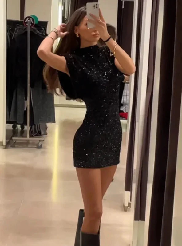 "Silver sparkly fitted dress with shoulder pads, perfect for a night out, made with premium shimmer fabric."